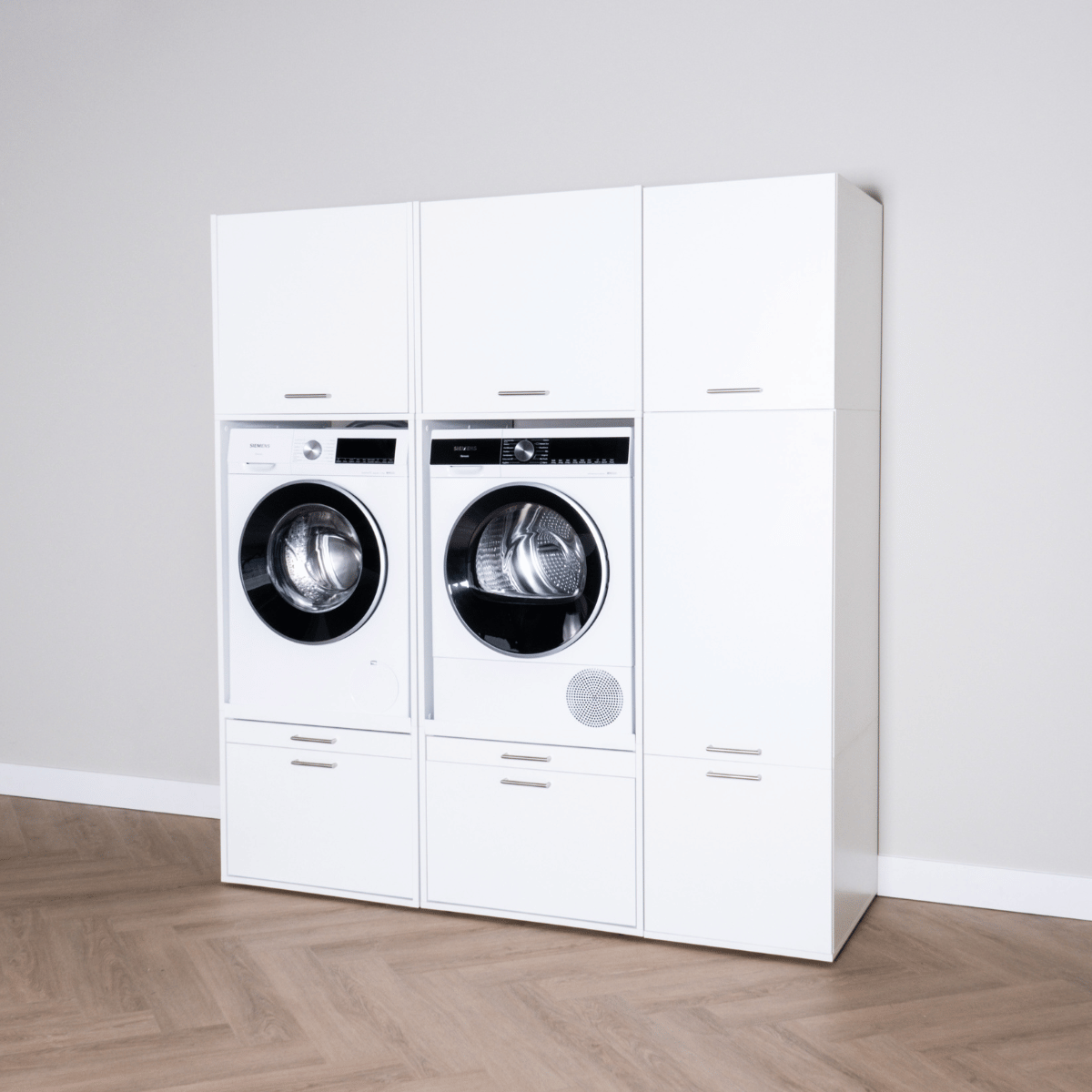 White modern laundry cabinet set with front-load washer and dryer, sleek storage compartments.