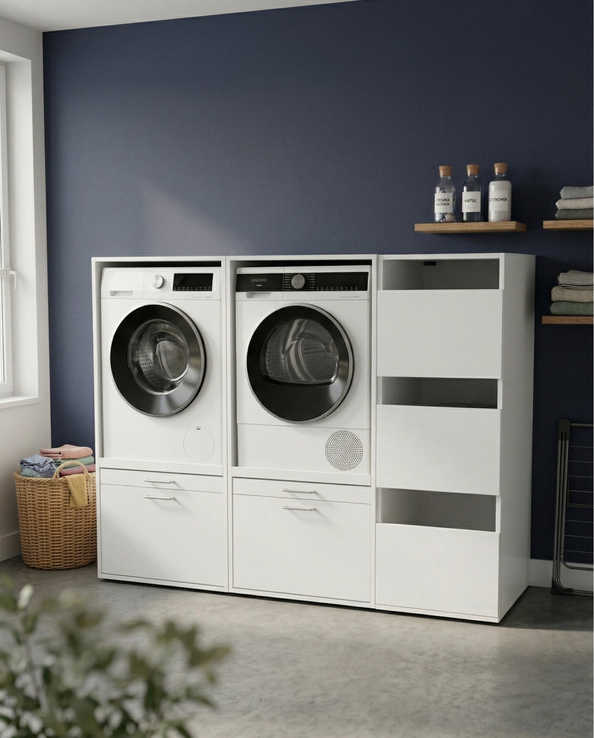 White Duo Set Low 3 laundry storage unit with front-loading washer, dryer, and side compartments against a dark blue wall.